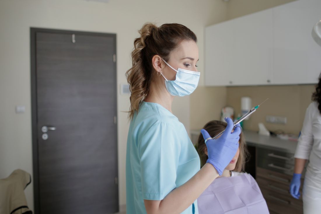 Odontóloga con mascarilla en el consultorio (imagen referencial)